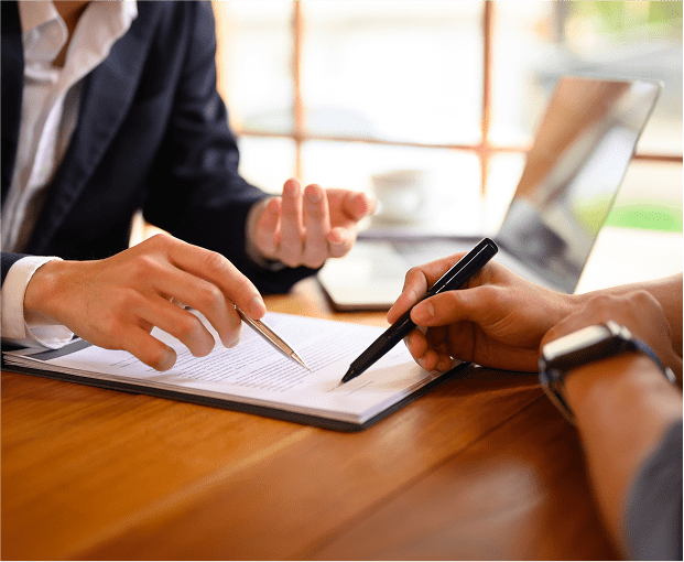 Close-up of hands signing documents