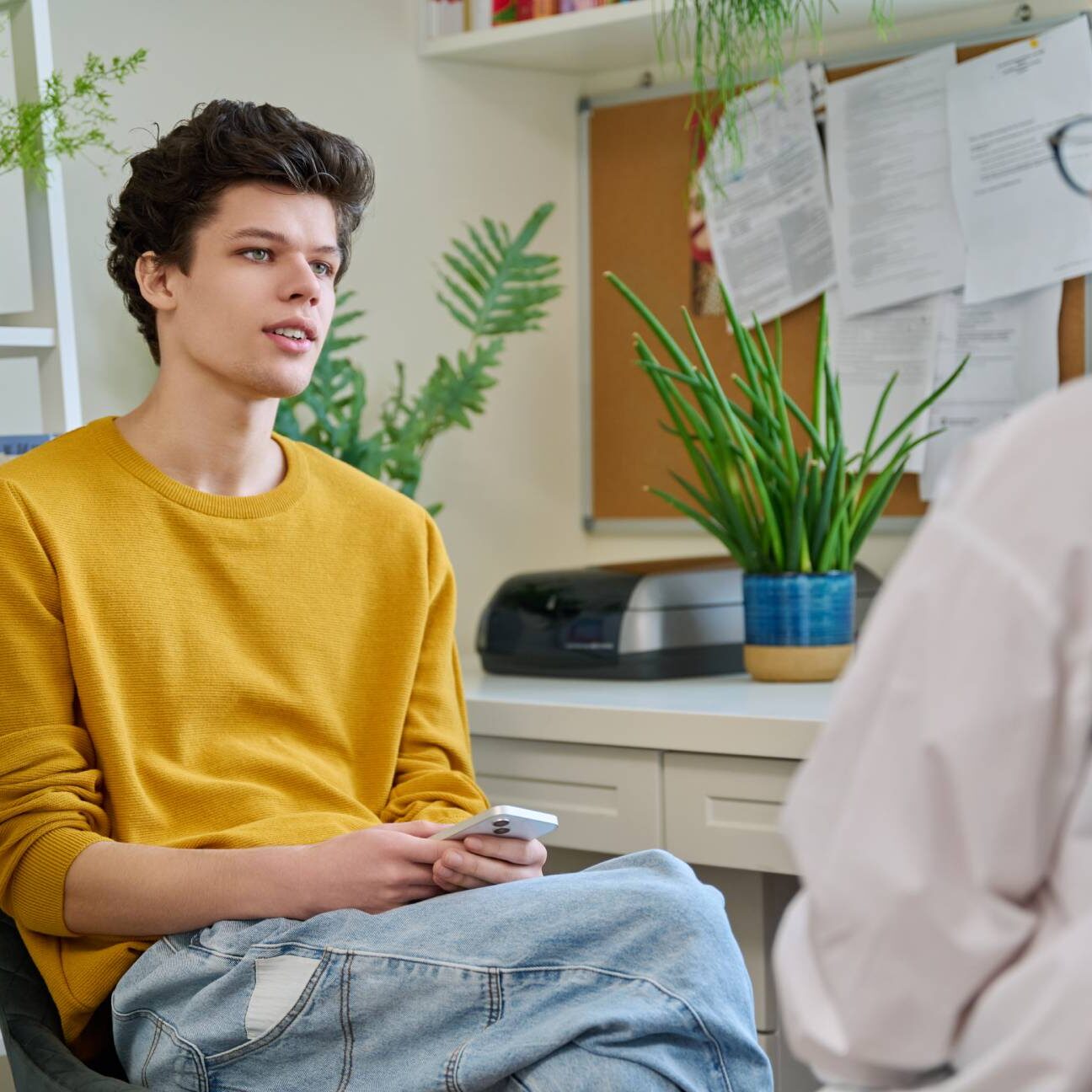 Young man attentively listening during a conversation in a cozy room.